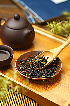 紫砂壶茶具和茶叶放在竹盘上