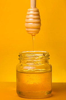 黄色背景下放在桌子上的蜂蜜