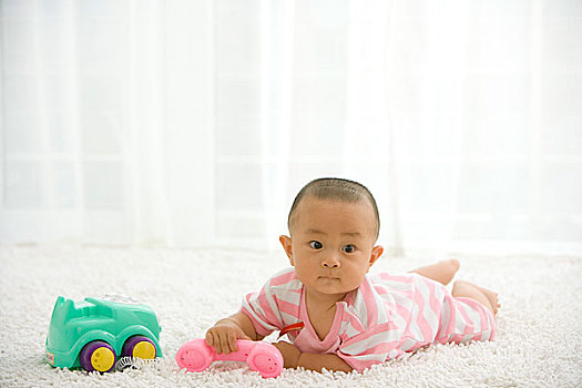 一个在地毯上玩耍的婴儿