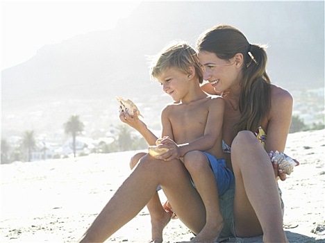 母亲,儿子,4-6岁,坐,沙滩,拿着,海螺壳,男孩,女人