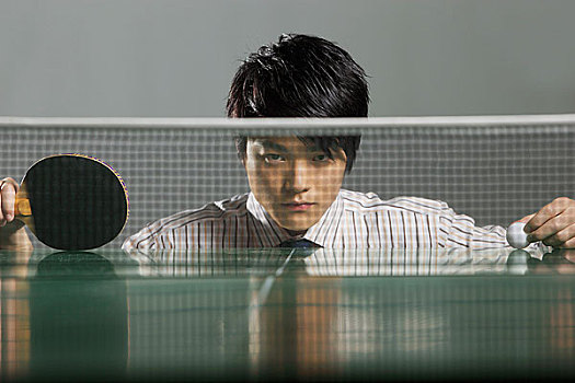 穿着商务衣服趴在乒乓球台的男人