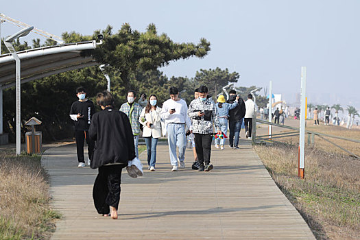 山东省日照市,面朝大海春暖花开,游客奔向海边休闲散步感受美好春天