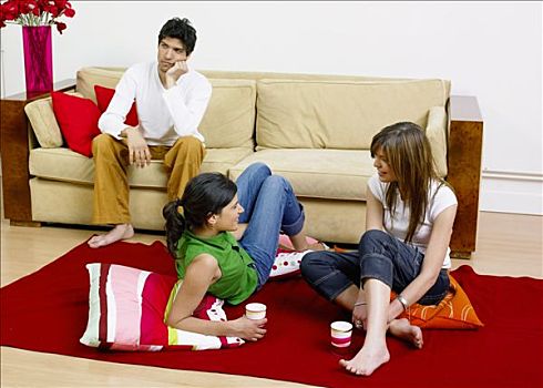 男孩,看,悲伤,坐,米色,沙发,背景,两个女孩,交谈,红地毯,垫子
