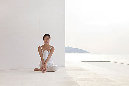 站在白色建筑前练瑜伽的美女