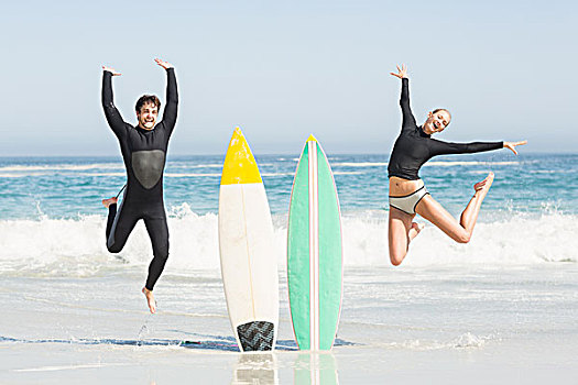 兴奋,情侣,跳跃,靠近,冲浪板,海滩