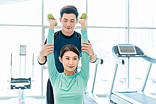 年輕女子在私教的指導下健身