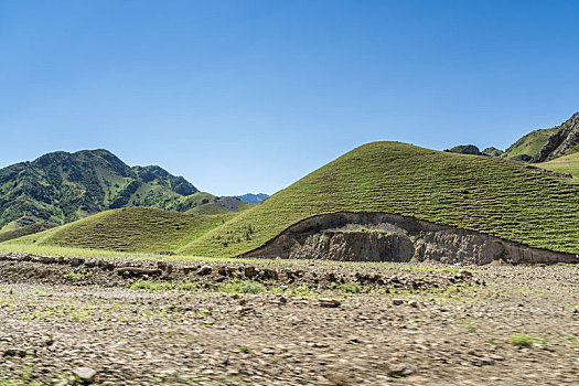 新疆蓝天白云下独库公路高原砂石路汽车背景