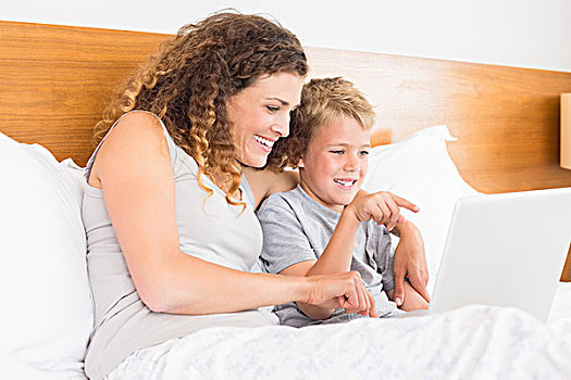 微笑,母亲,儿子,坐,床,看,笔记本电脑