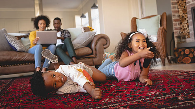 美国黑人,兄弟姐妹,躺着,地面,看电视,父母,使用笔记本,沙发