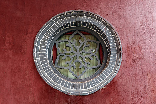 红色墙面上的圆形砖砌漏花窗,山东省泰安市岱庙古建筑
