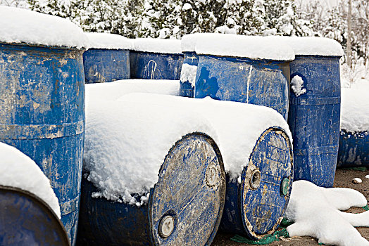蓝色的金属桶在雪地上