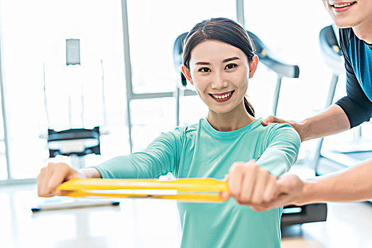 年輕女子在私教的指導下健身
