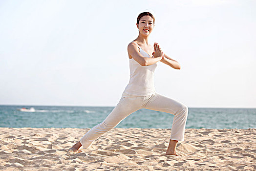 在沙滩上练瑜伽的女士