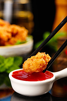 筷子上夹着沾番茄酱的黄金鸡米花