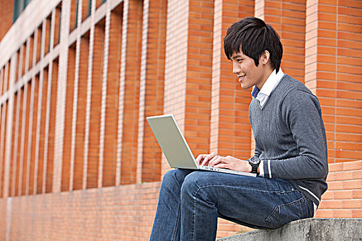 年轻大学生在校园里使用笔记本电脑