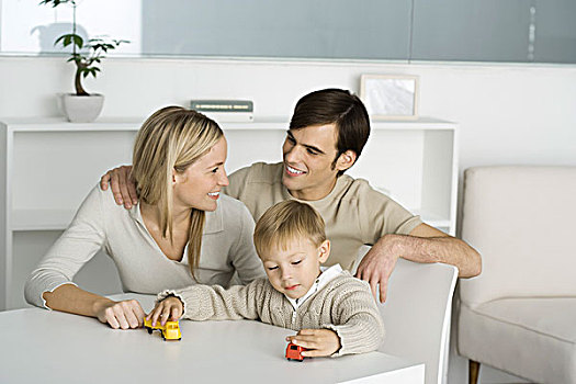 家庭,桌子,男孩,玩,玩具卡车,父母,微笑,相互