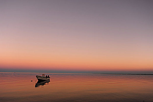 madagascar,tulear,ifaty,pink,sunrise,with,small,boat,in,the,ocean