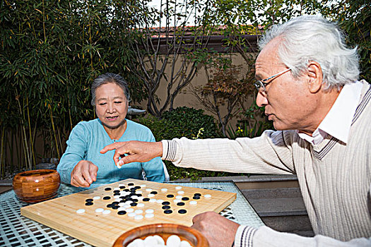 老夫妻在庭院里下棋