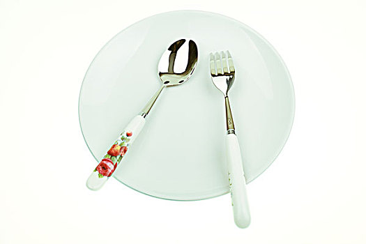 白色盘子中放着银色叉子和勺子