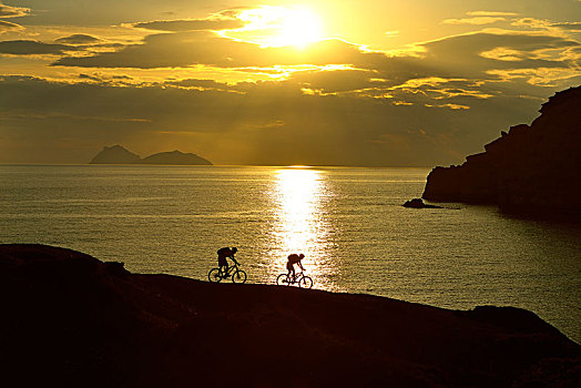 两个,山地车手,骑自行车,岩石海岸,逆光,日落,红色,海滩,马塔拉,克里特岛,希腊,欧洲