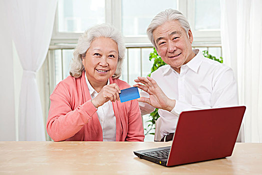 一对老年夫妇拿着信用卡