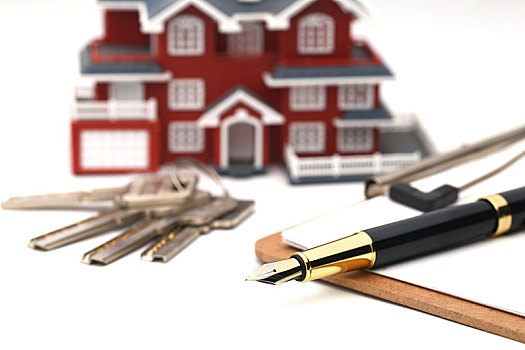 房屋模型,钥匙和钢笔放在白色背景上