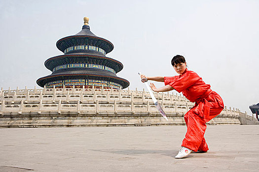 中國武術--一名女武術運動員在天壇祈年殿前練刀法