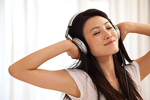 年輕女人戴耳機聽音樂