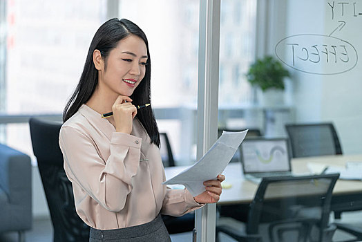 年輕商務女士拿著文件