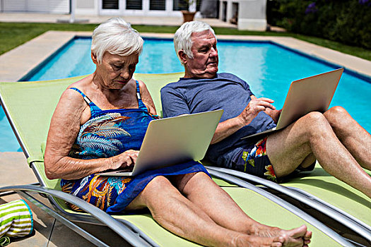 老年,夫妻,使用笔记本,休闲椅,池边