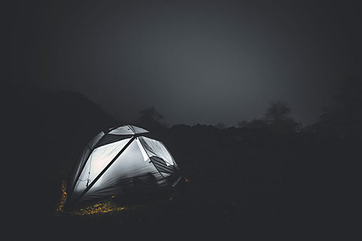 在山上星空下的被雾气缭绕的帐篷