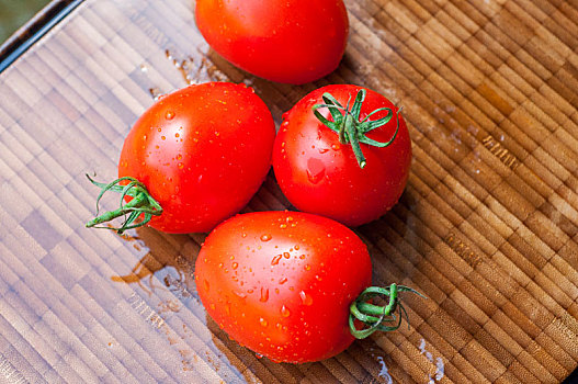 阳光下新鲜的西红柿在木质的砧板上