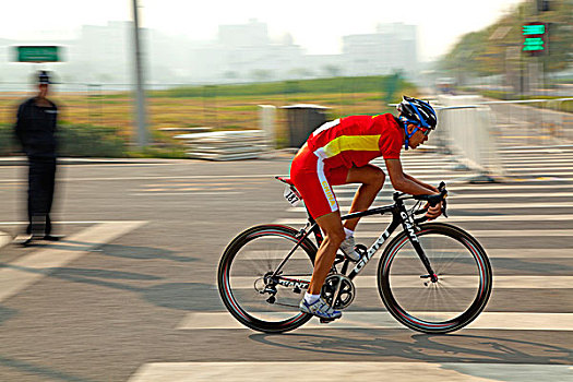 骑着公路自行车在公路上进行比赛的白人选手