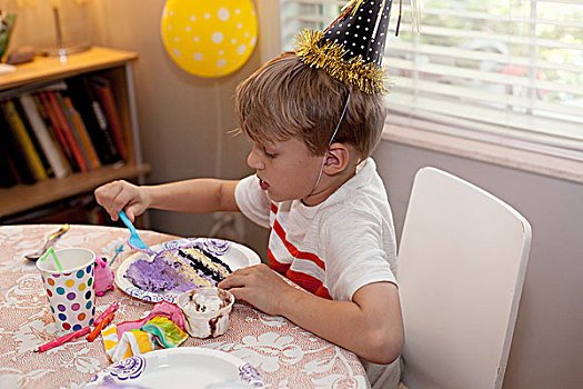男孩,派对帽,坐,桌子,吃,生日蛋糕