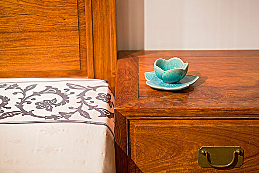 床头柜上有一套荷花造型的蓝瓷碗摆件asetoflotusshapedbluechinacuponanighttable
