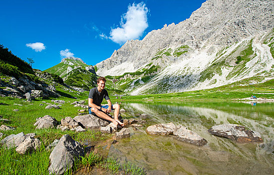 男青年,坐,石头,高山湖,阿尔卑斯山,巴特辛德朗,巴伐利亚,德国,欧洲