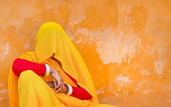女人,穿,红色,黄色,纱丽,薄纱,遮盖,头部,坐在地板上,倚靠,橙色,墙壁