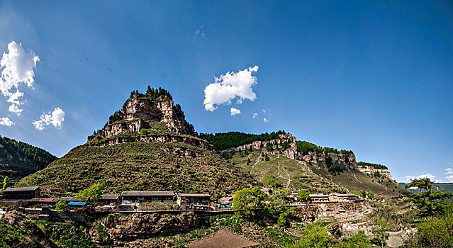 远眺位于大山半山腰的山西宁武县涔山乡悬空村,悬崖上的村庄