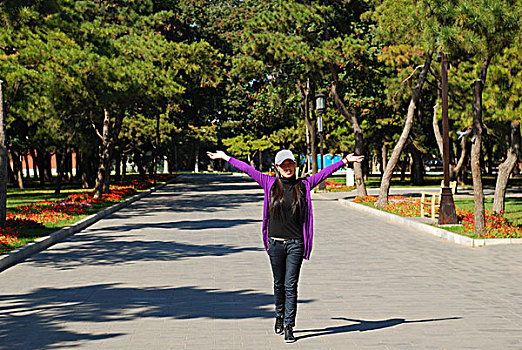 一名年轻女性走在公园的路上