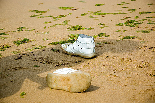 海边沙滩上放着的儿童鞋