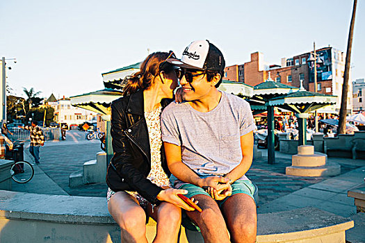 浪漫,年轻,情侣,坐,墙壁,海岸,威尼斯海滩,加利福尼亚,美国