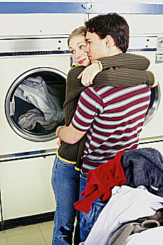 年轻,情侣,搂抱,自助洗衣店