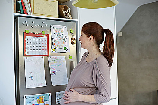 孕妇,看,日历,电冰箱