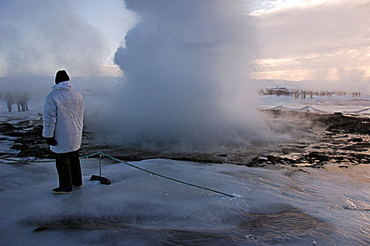 iceland,geysir,tourist,people,looking,at,steam,coming,out,from,the,geyser,in,snow,environment