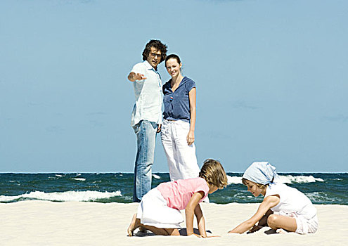 家庭,海滩,父母,看,女儿,玩,沙子