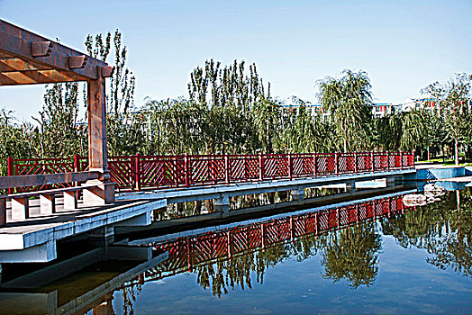 湖泊中倒映着红色栏杆的桥