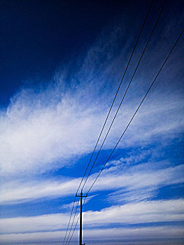 蓝天白云下的电线杆