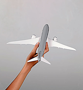 一只手向上捏着飞机模型