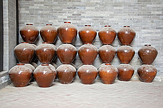 大量陶瓷罐子堆放在墙角边