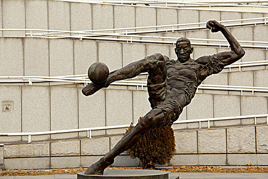 飞身踢足球的人物雕塑